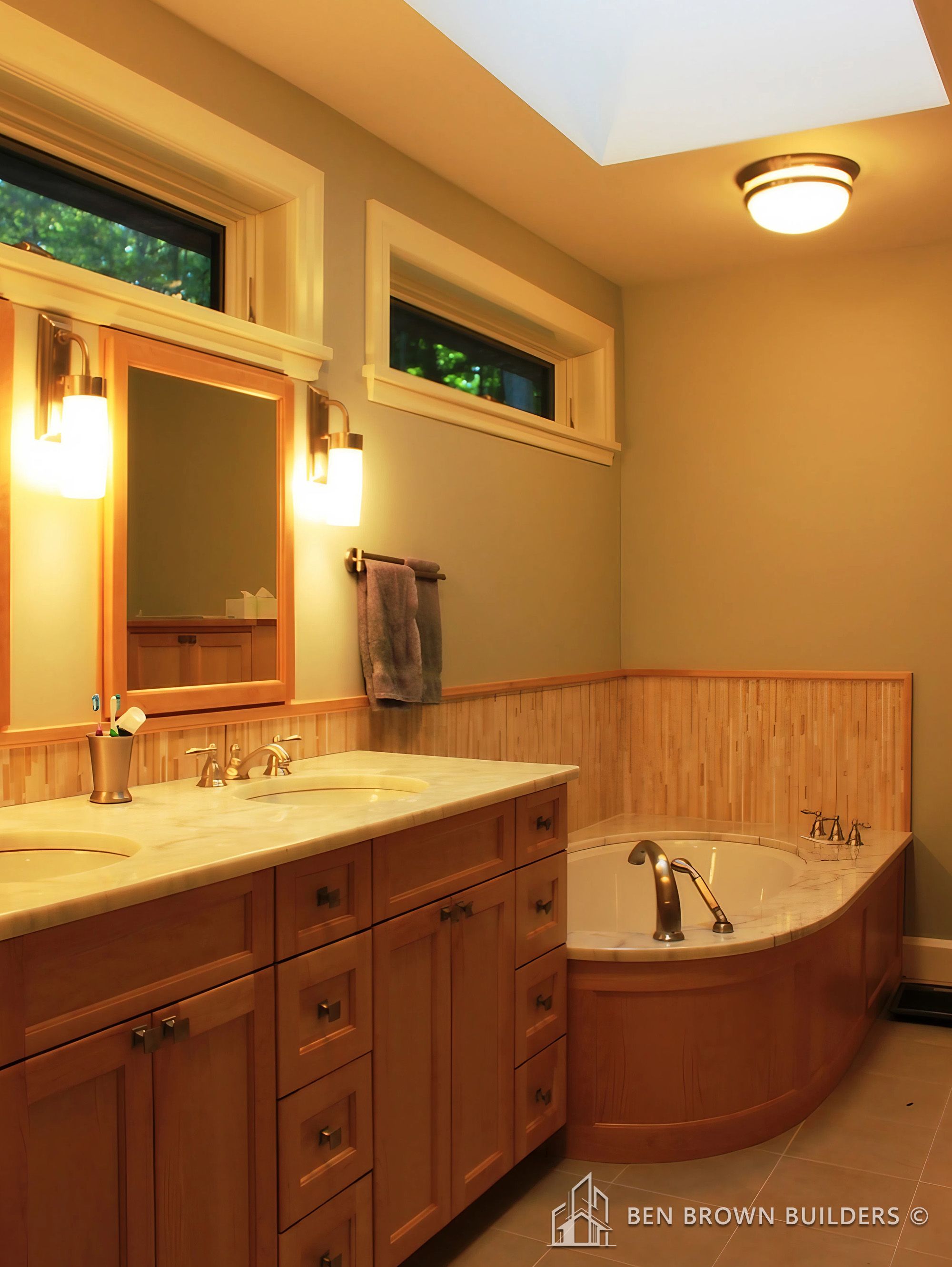 Chic bathroom with a navy blue vanity, double sinks, two framed mirrors, and vintage-style wall sconces