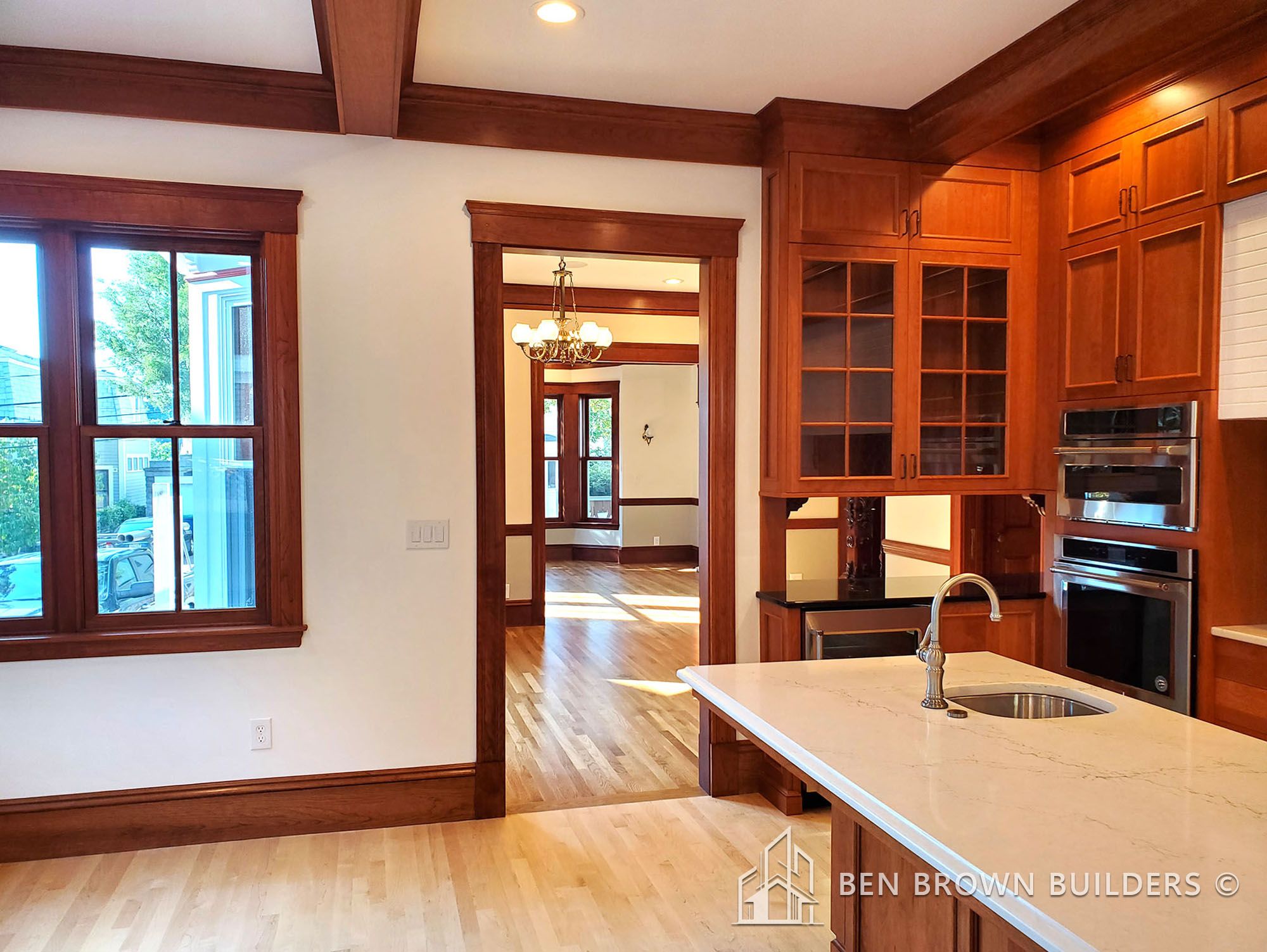 Open kitchen with wooden cabinets, stainless steel appliances, and an island overlooking a dining area