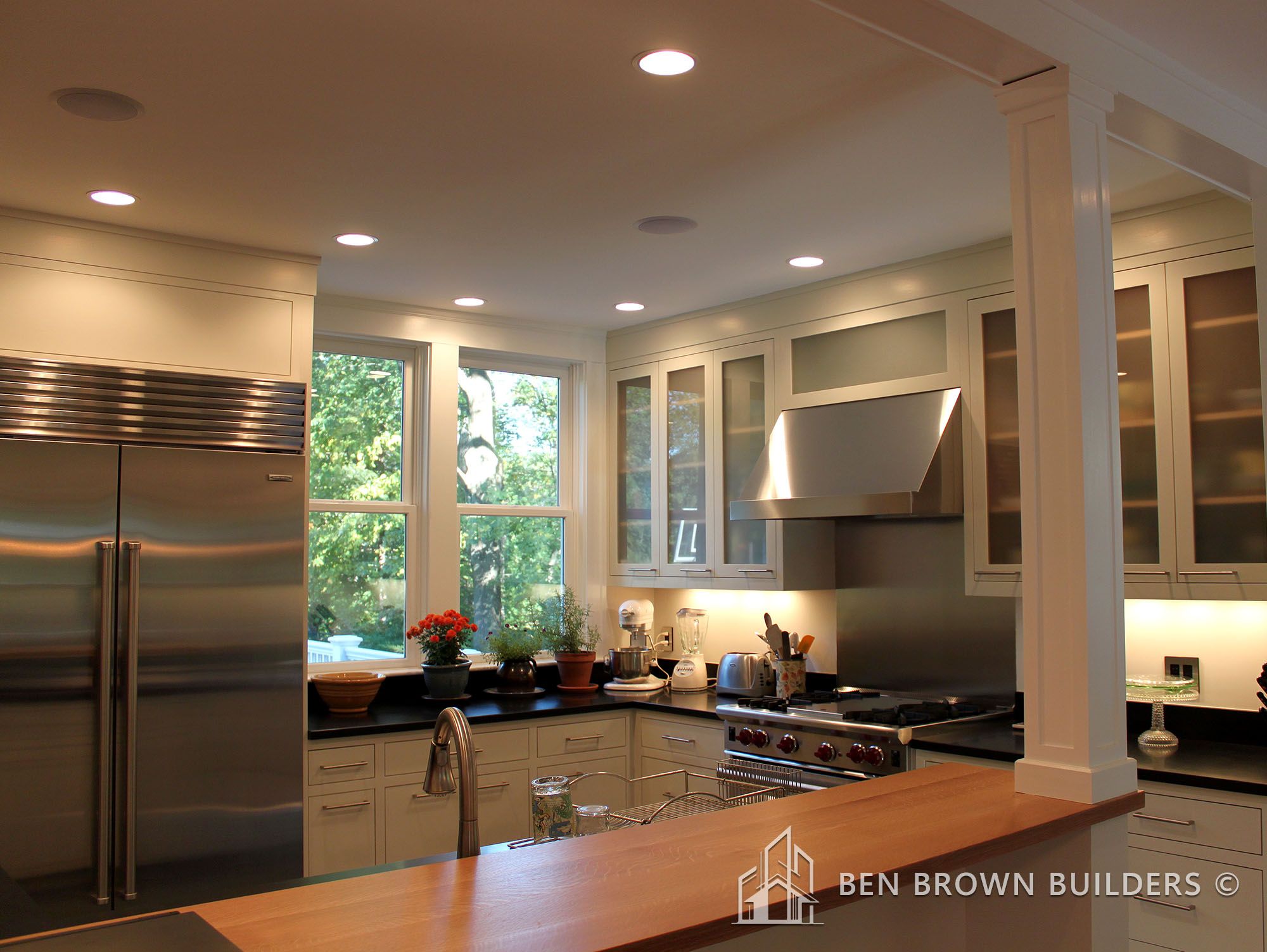 Spacious kitchen with stainless steel appliances, wooden countertops, and ample natural light